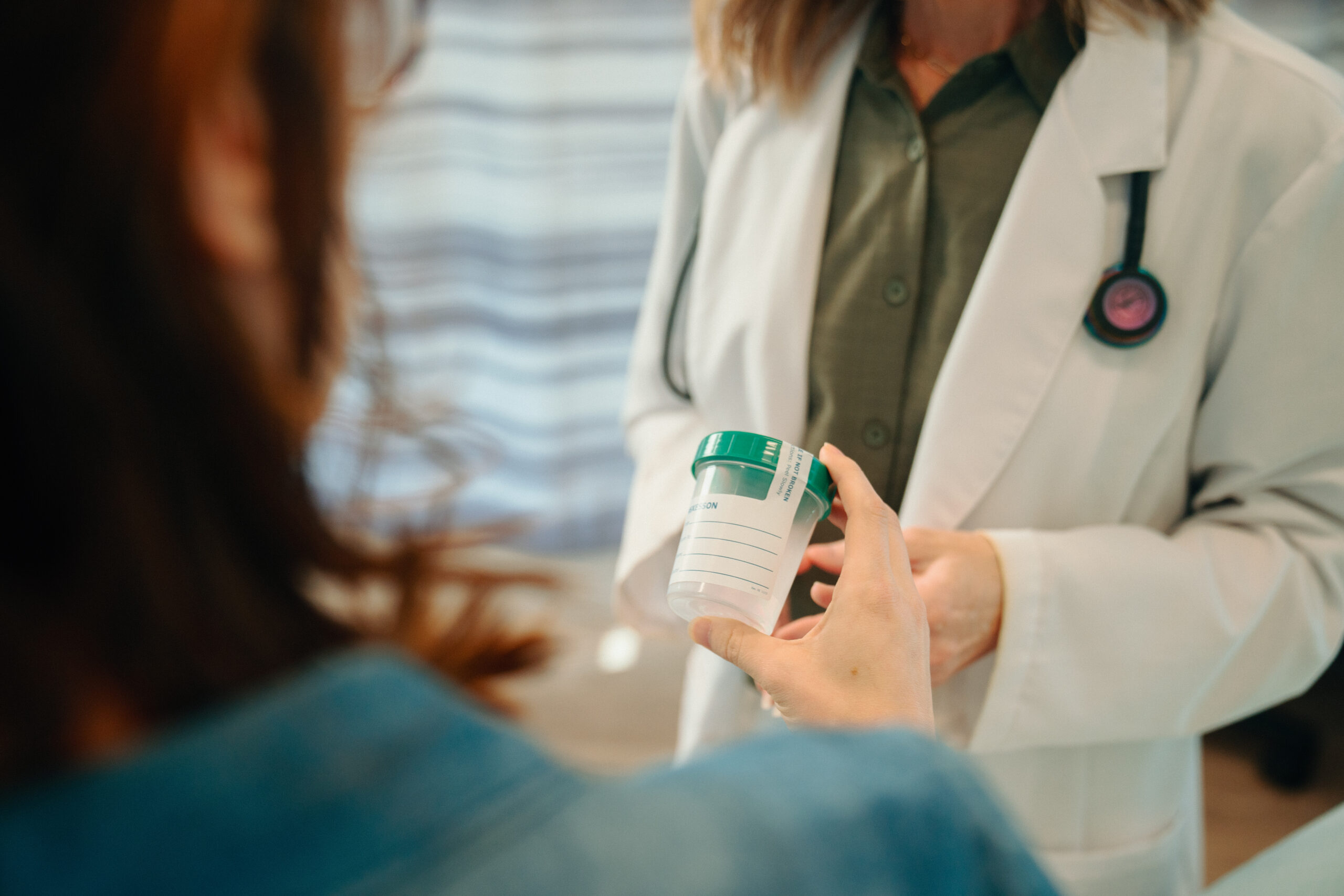 AFC patient holds urine sample cup